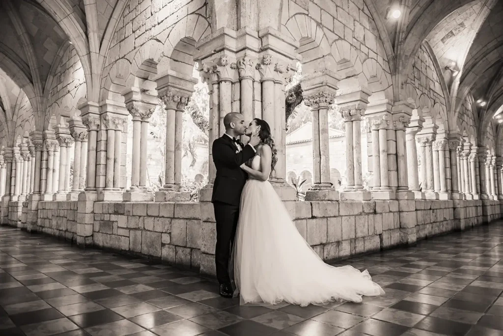 black and white photo of bride and groom by dramatic architecture