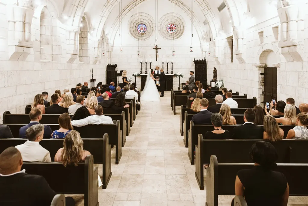 weding ceremony inside an all white nistoric cathedral
