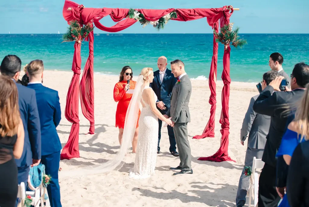 Beach ceremony in South Florida ith red wrapped altar