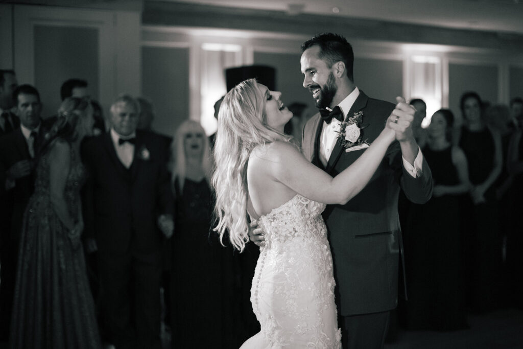 black and white photo of bride and groom happy first dance