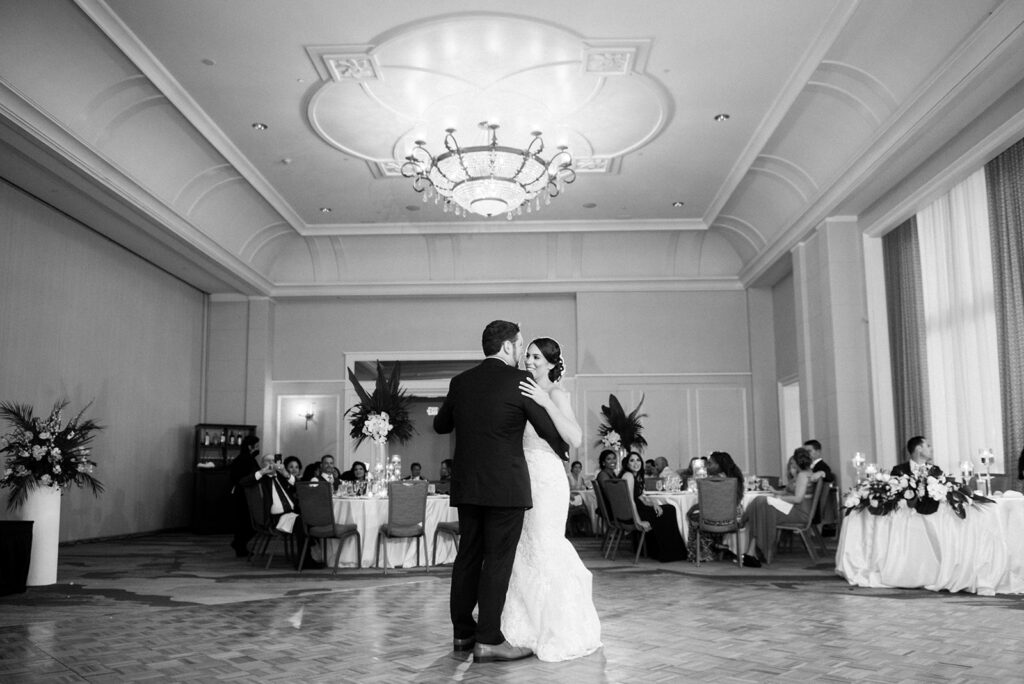 black and white photo bride and groom dancing in ballroom