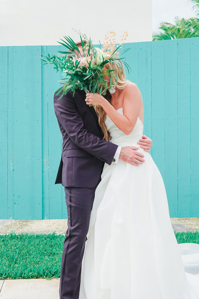 bride and groom hiding behind bouquet