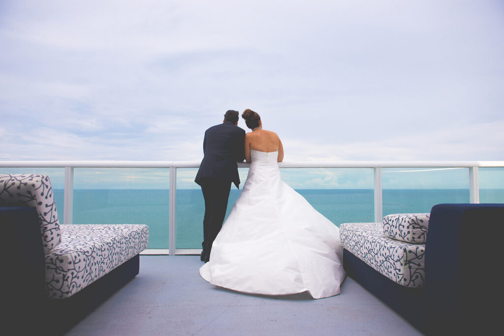 bride and groom staring out at ocean
