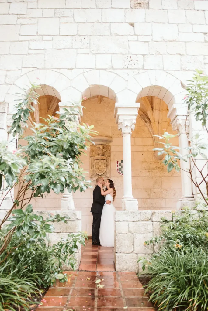 bride and groom kissing in ancient spanish monastery
