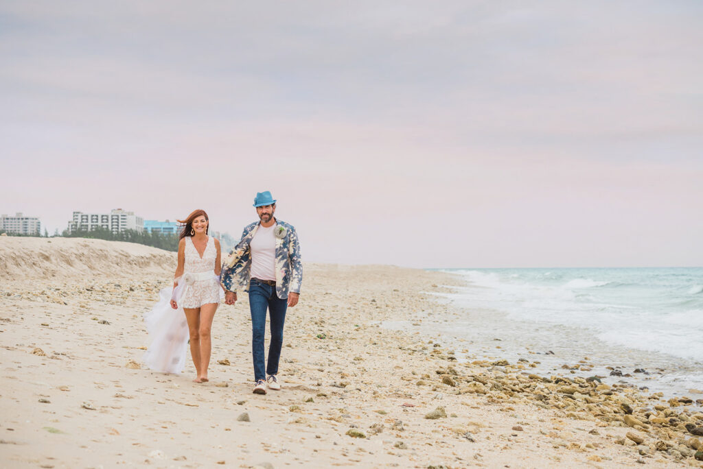 bride and groom walk on secluded beach