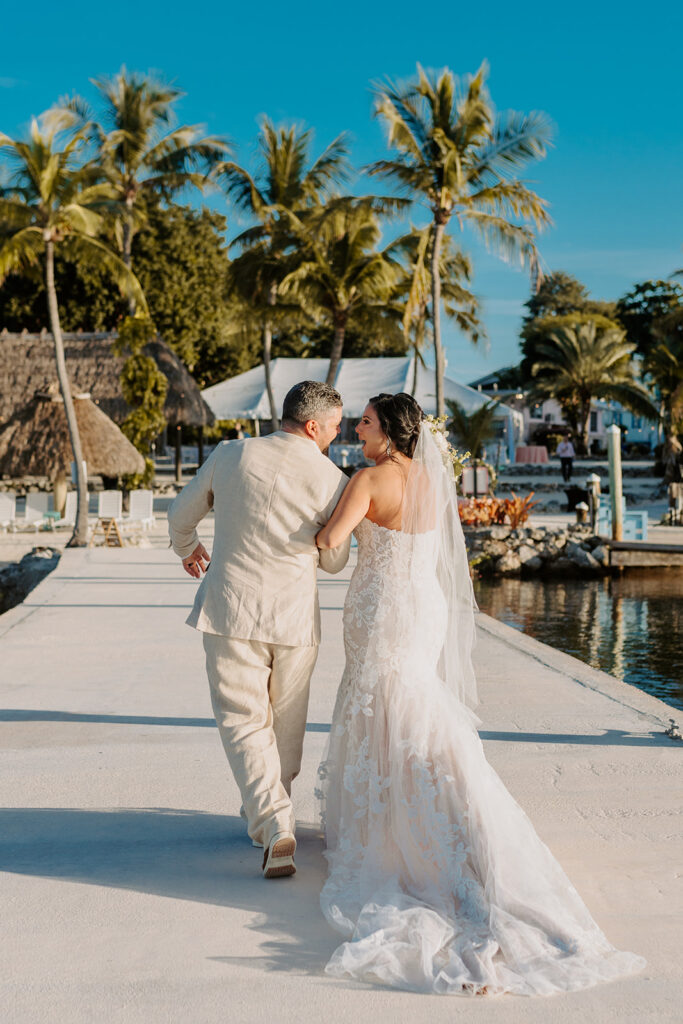 bride and groom walking by palm trees