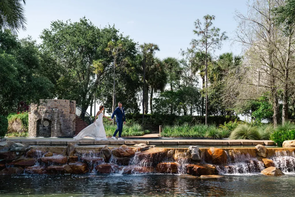 bride and grom walking along water feature and pond