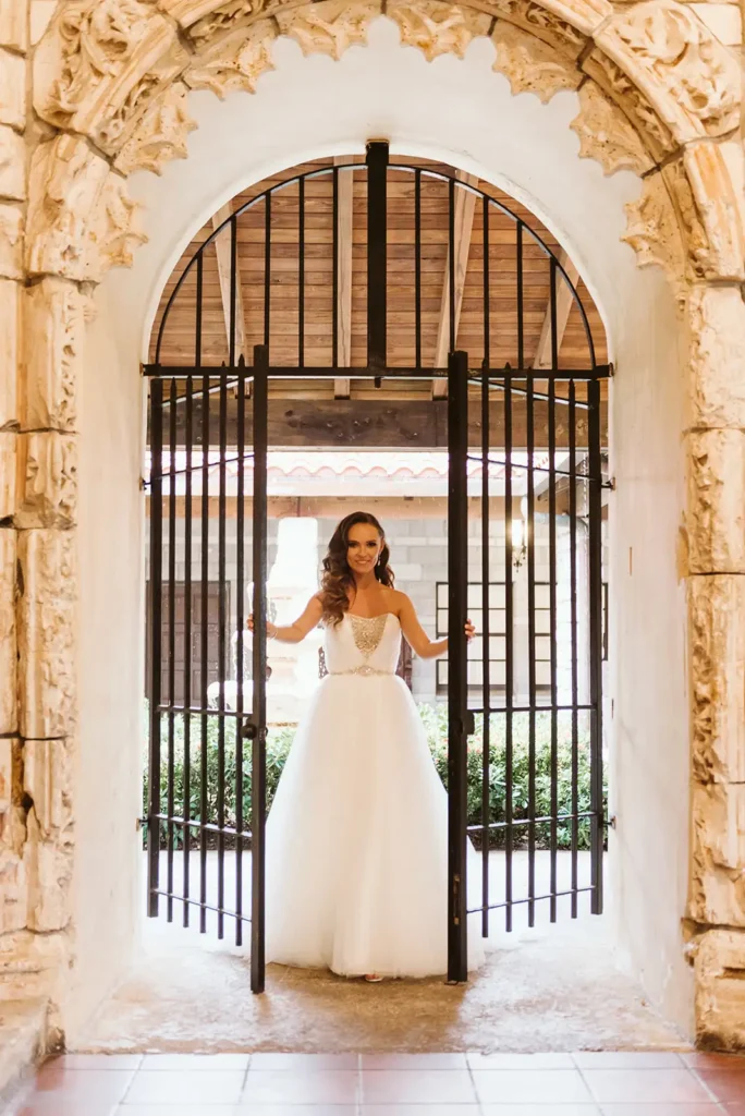 bride opening iron gates at South Florida wedding venue