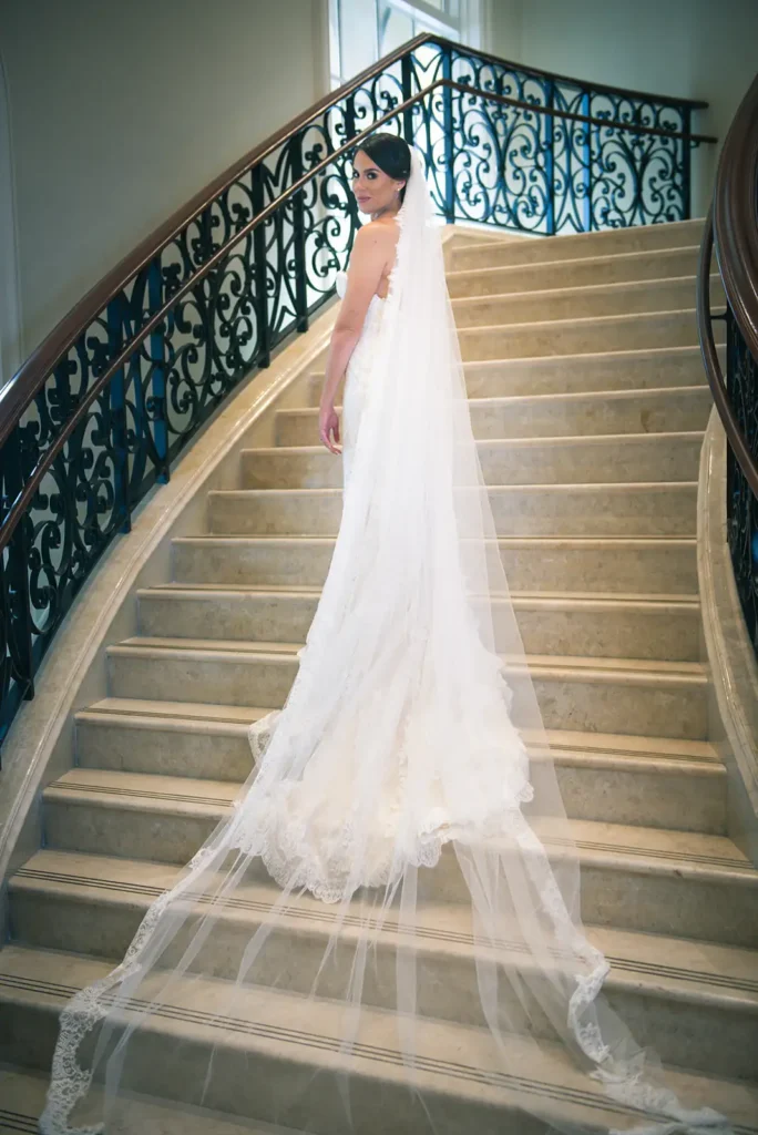 bride standing on stairs with long veil