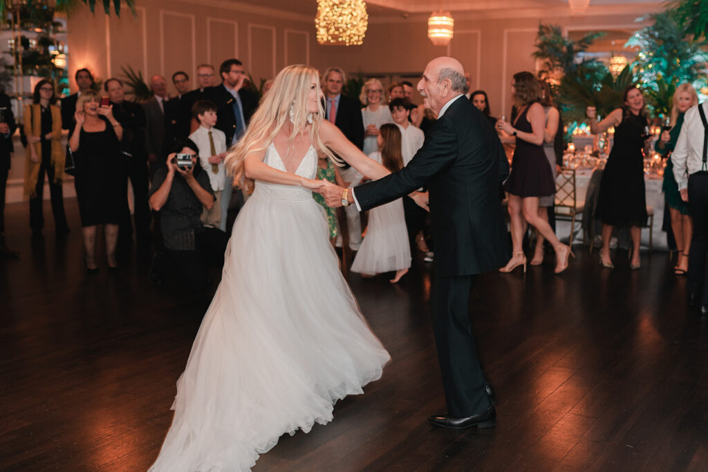 Father daughter dance in dimly lit ballroom