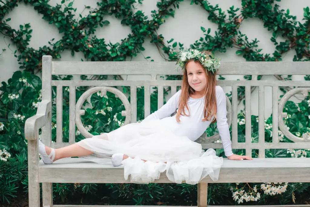 flower girl posing on an outside bench