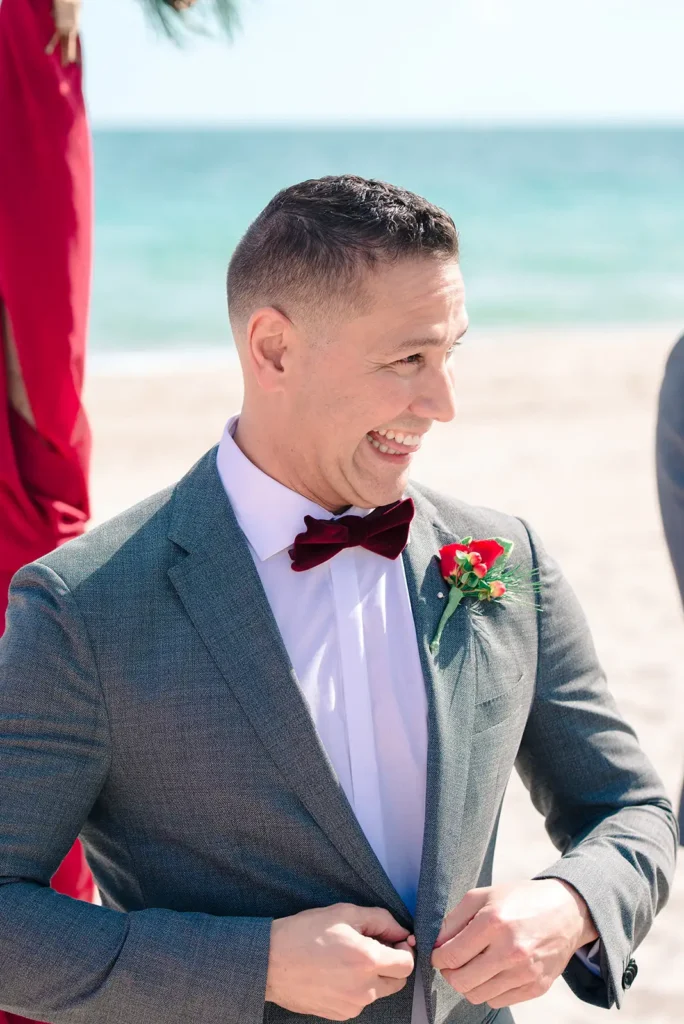 groom grins widely at bride during ceremony