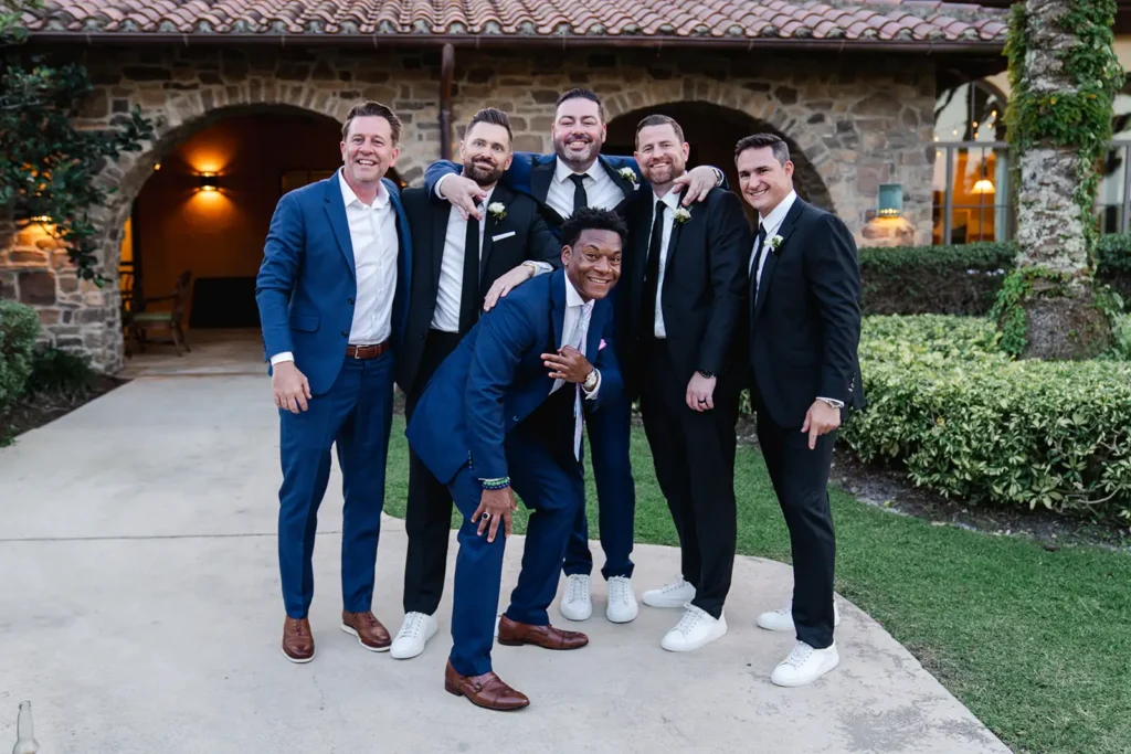 groom and groomsmen poe for camera