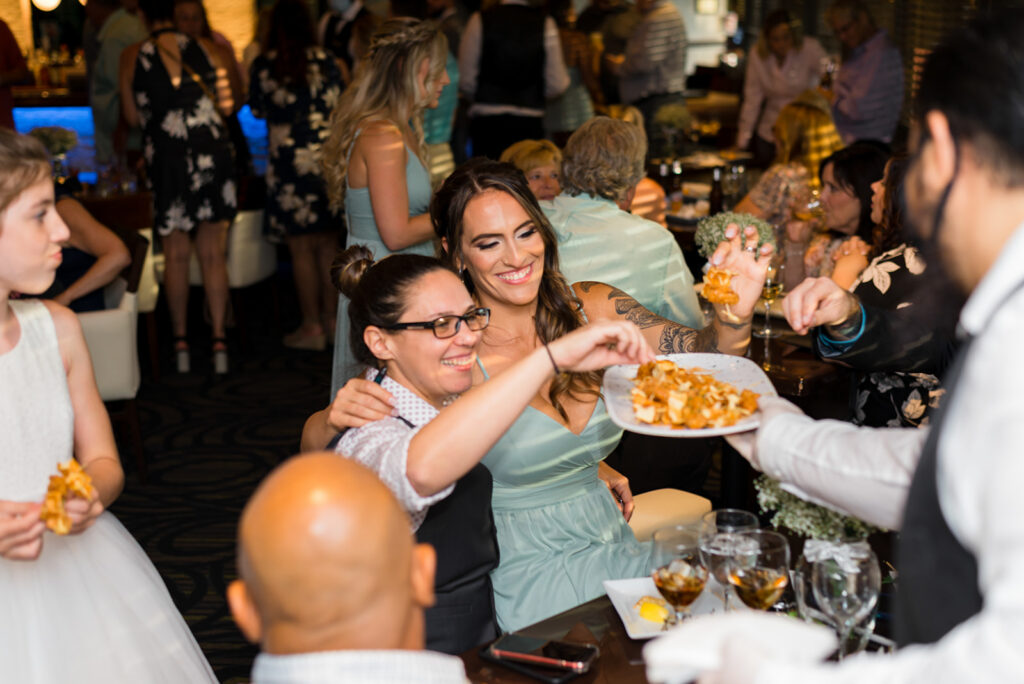 wedding guests eat hors d'ouvres served by waiter