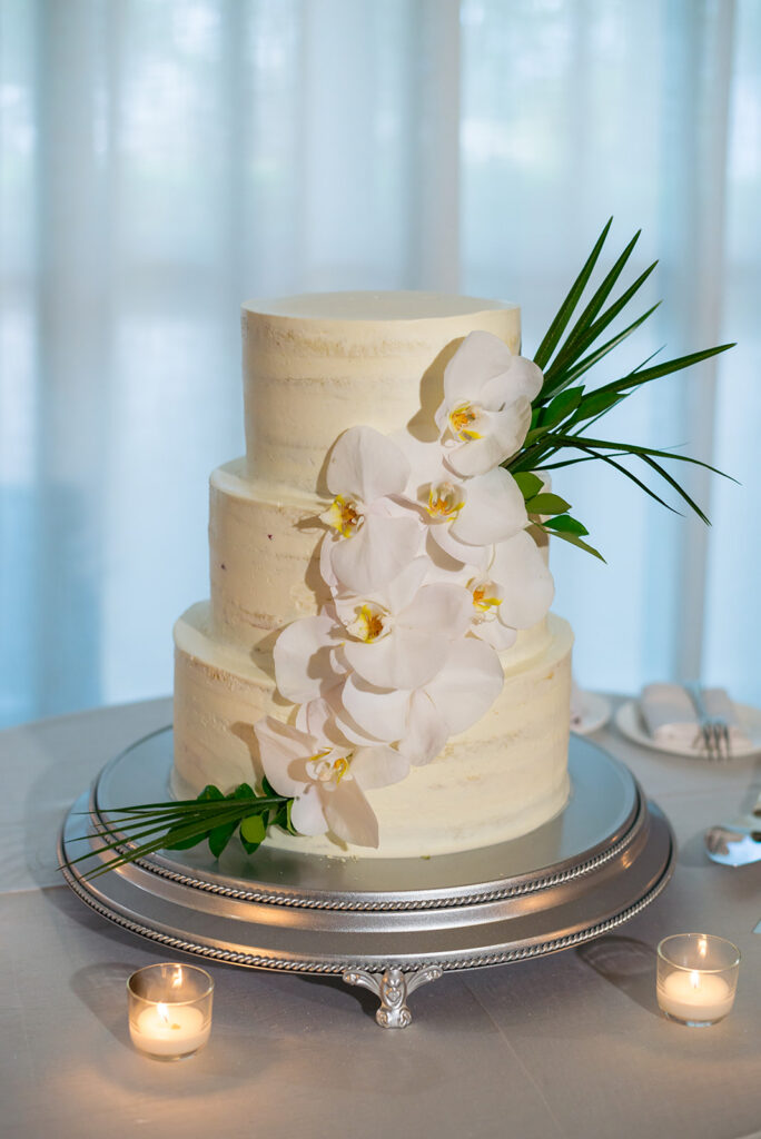 three tier white wedding cake with white flowers