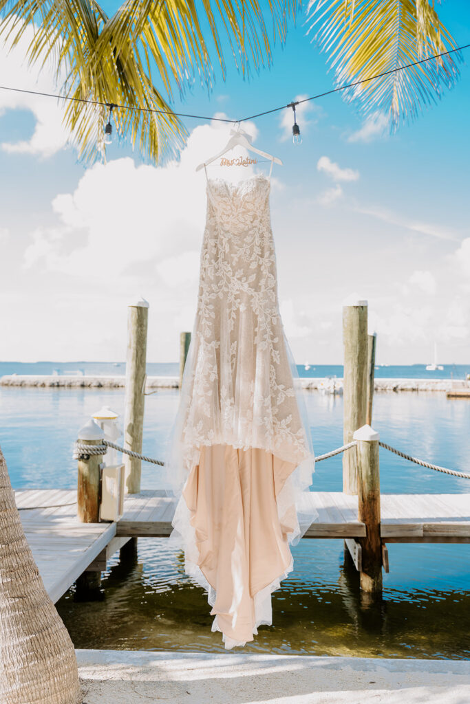 wedding dress hanging by dock at oceans edge