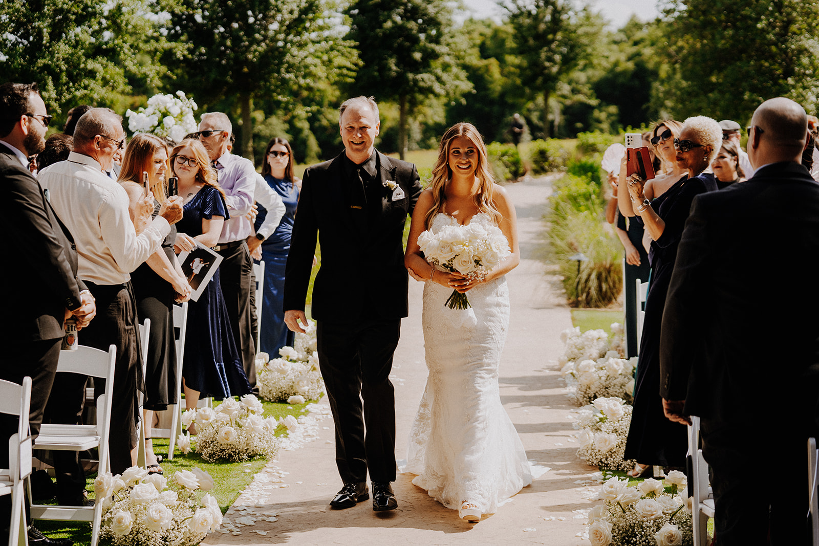 Bride walking down the aisle with father at an outside wedding ceremony
