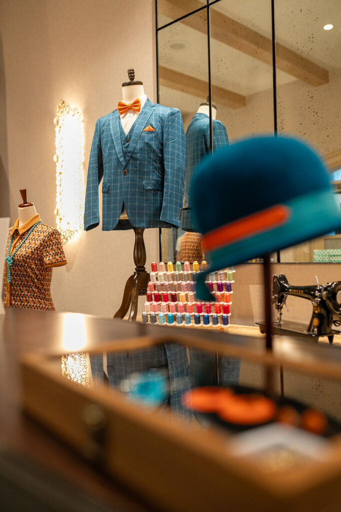 man's suit coat and woman's hat in an alterations set of an immersive corporate event