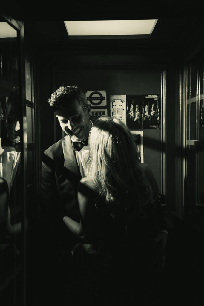 black and white photo of couple laughing in a vintage photo booth