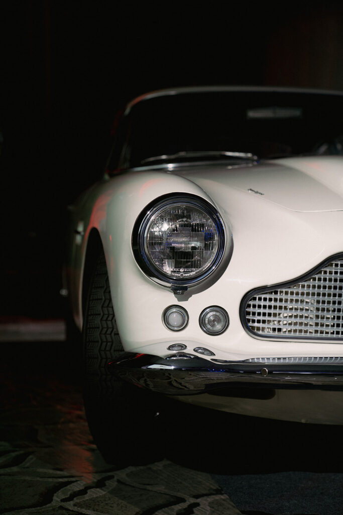 Front of a white antique car showing headlight