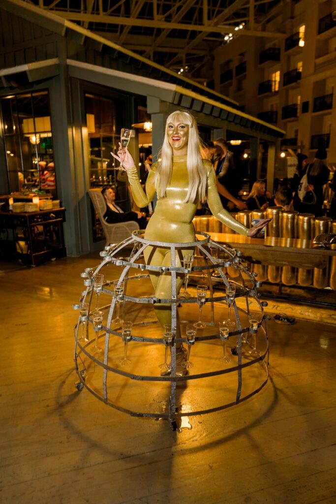 Golden clad entertainer serving drinks fron her skirt