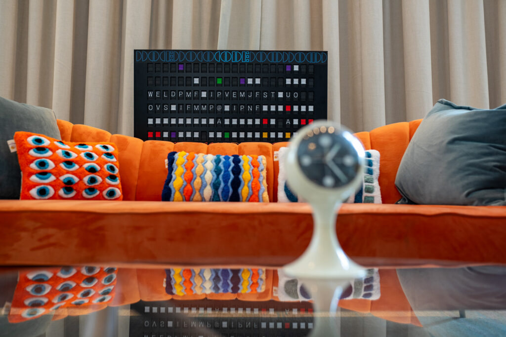 vintage orange couch with blue and orange throw pillows
