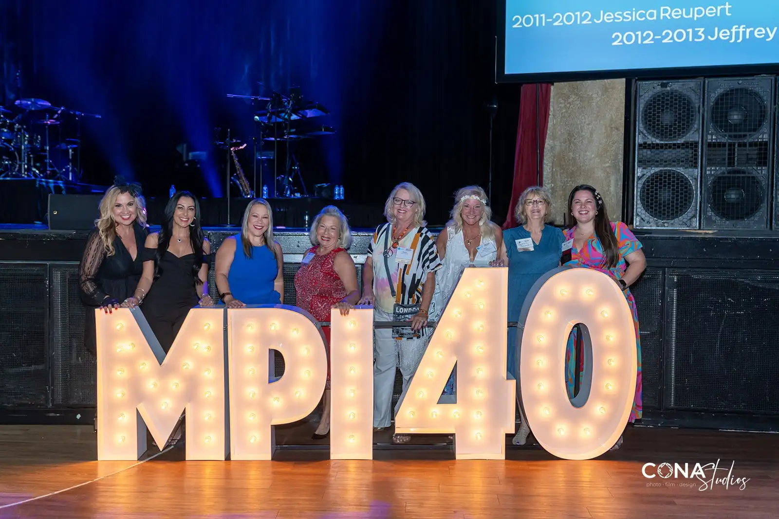 MPI Networking attendees by MPI 40 lighted sign