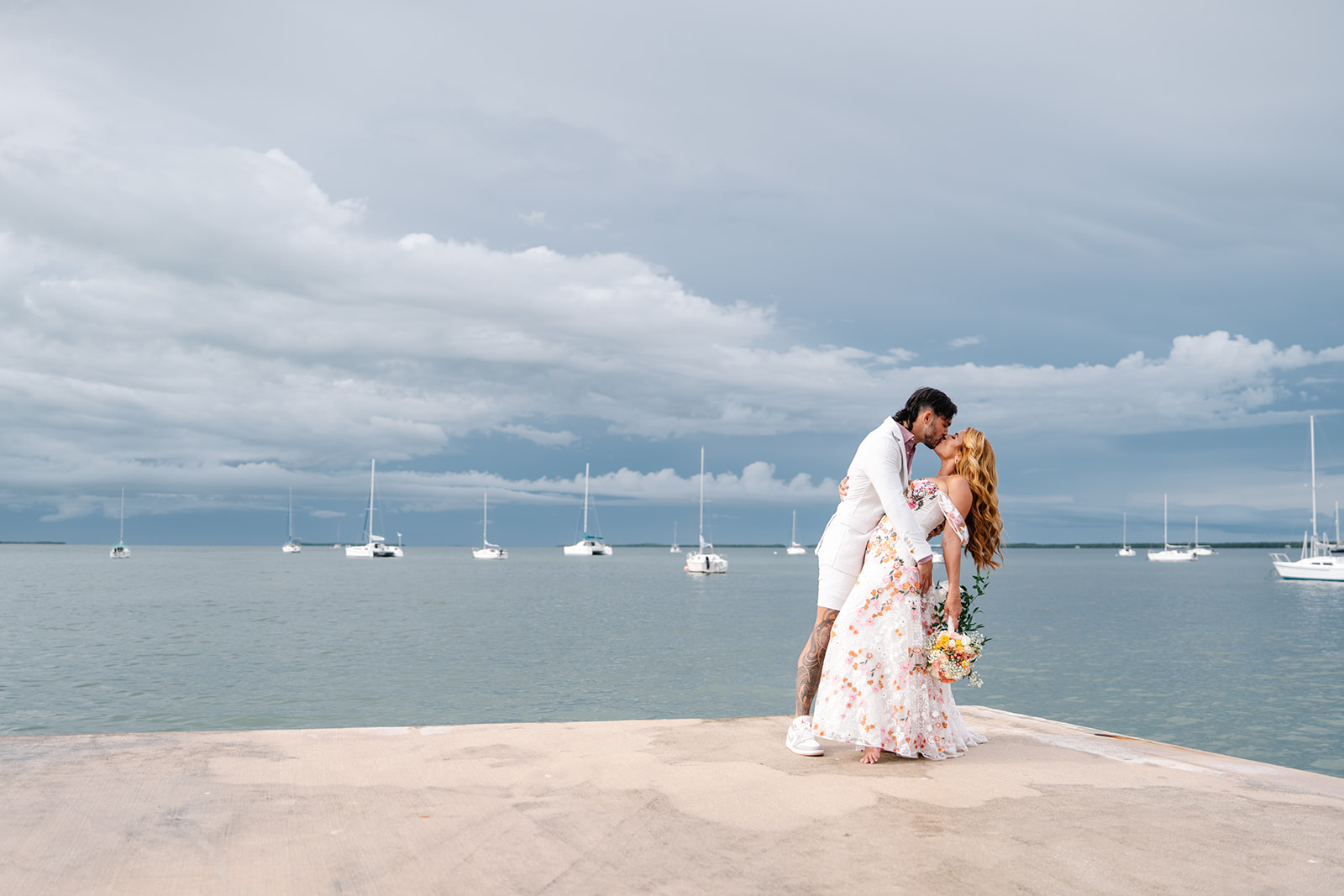 Groom dipping bride on a dock oceanside in South Florida