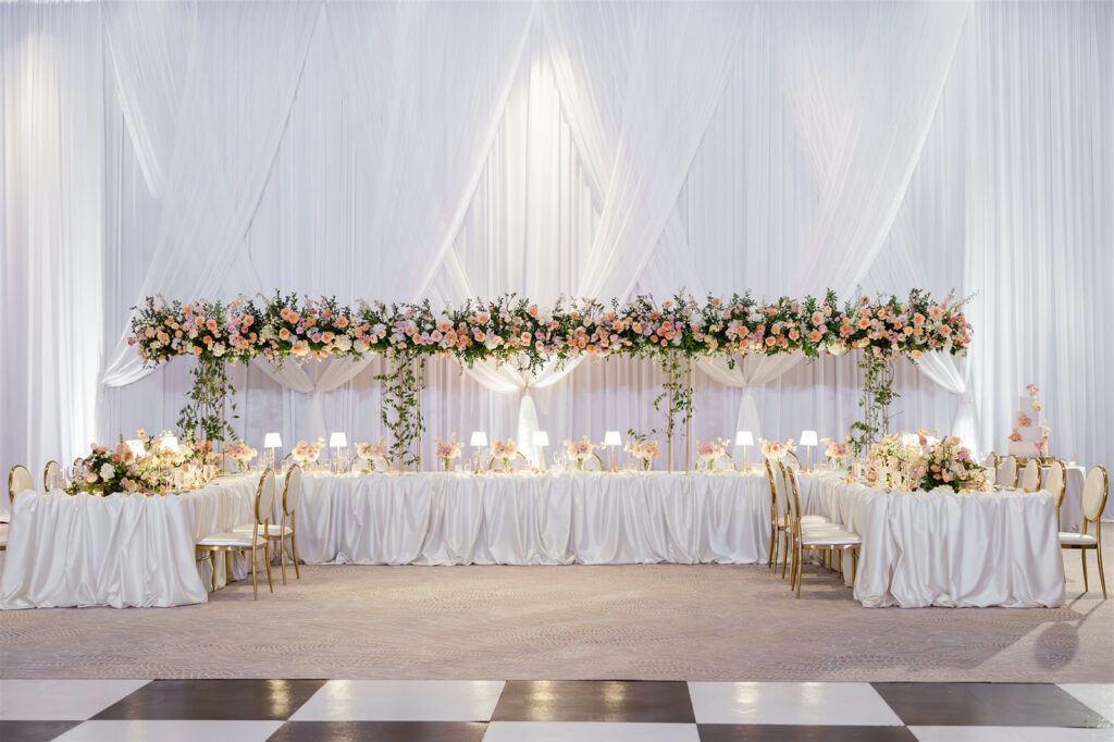 Luxurious white draping behind wedding head table