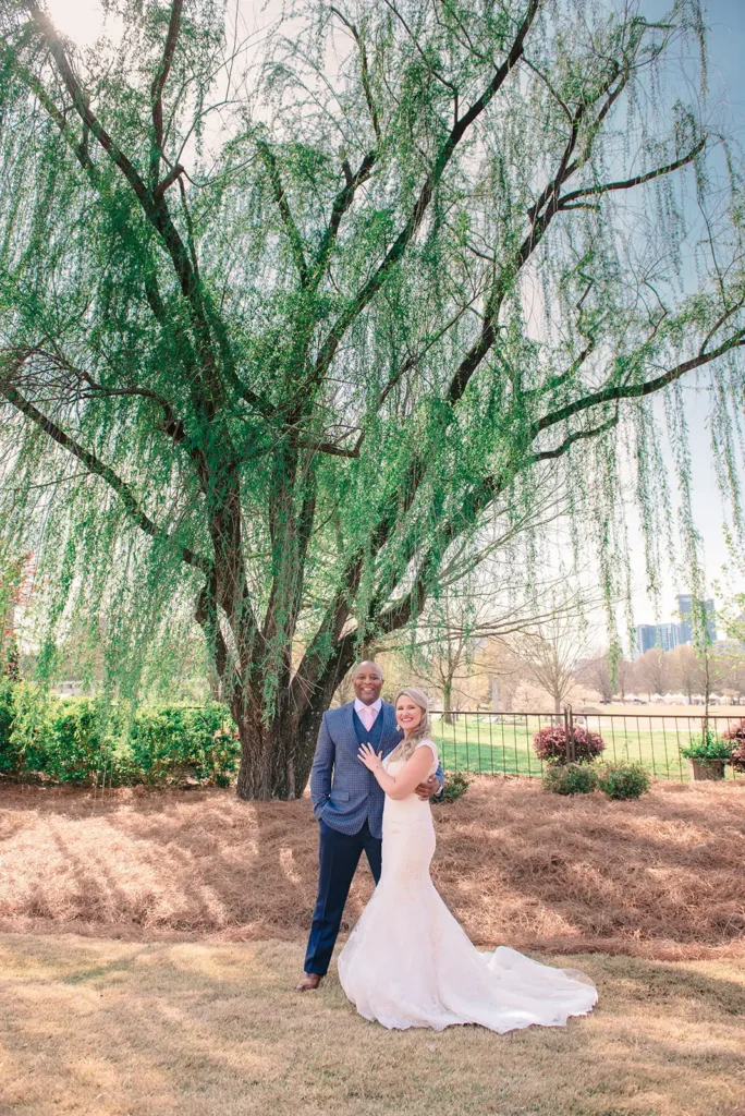 Bride and groom under large tree with Atlanta in background