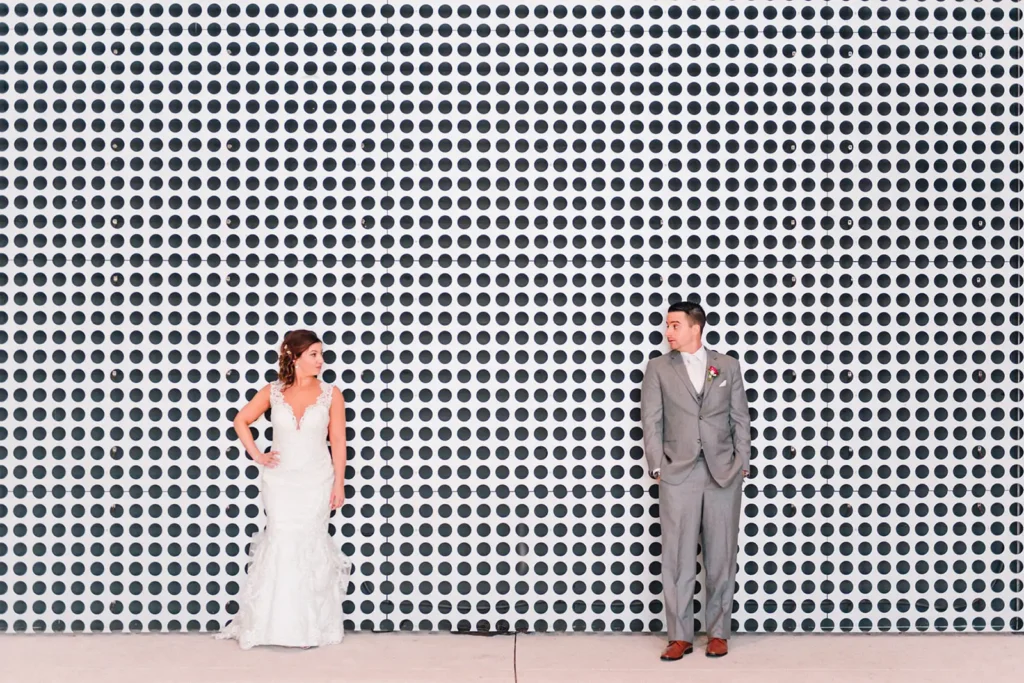 Bride and groom leaning on large black and white polka dot wall in Tampa, FL