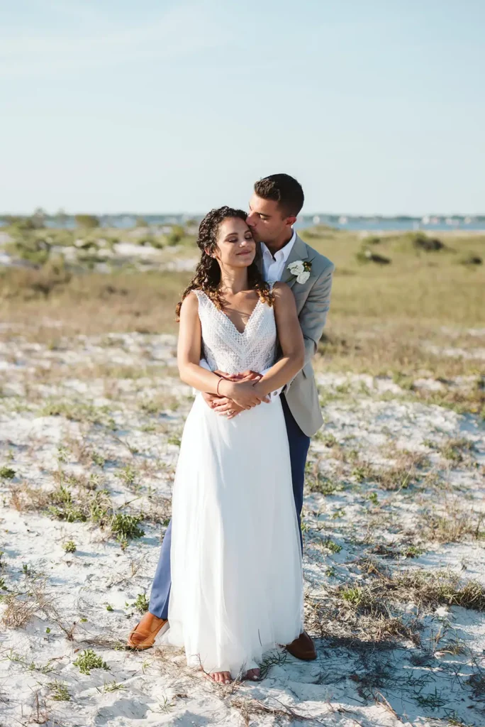 Bride and groom standing near ocean