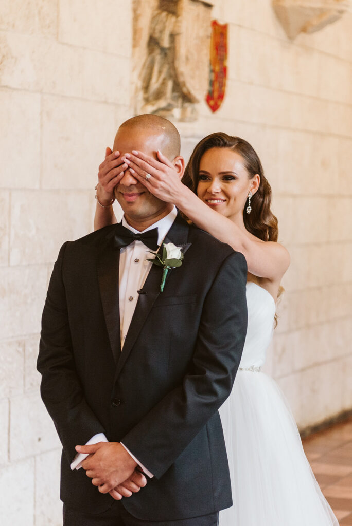 bride covers groom eyes