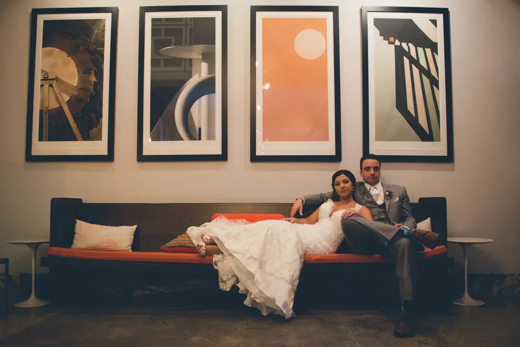 Bride and groom on beach with large art installation