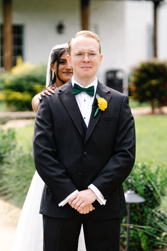 Bride touches groom shoulder during first look