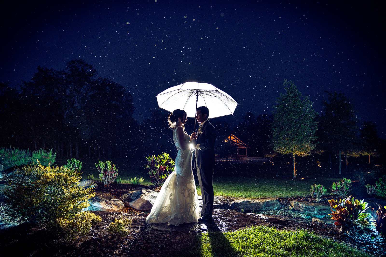 bride and groom under umbrella at night under a starry sky