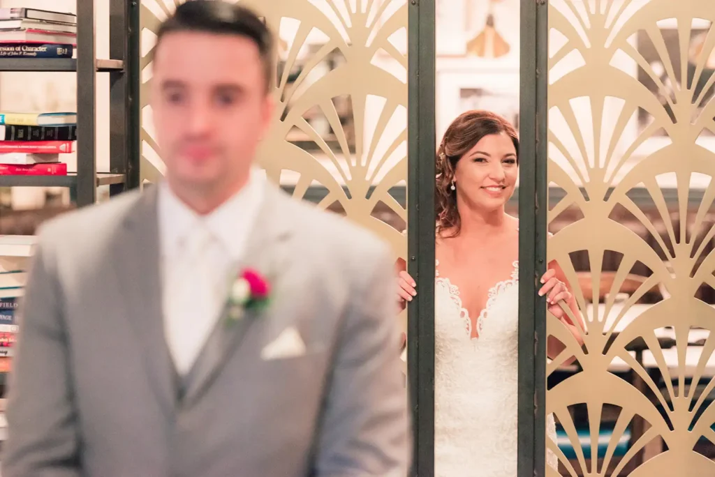 Bride peeks through large gates for first look with groom