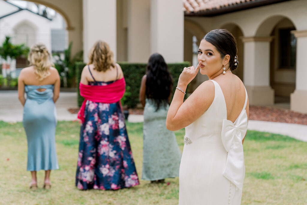 bride shh first look with bridesmaids