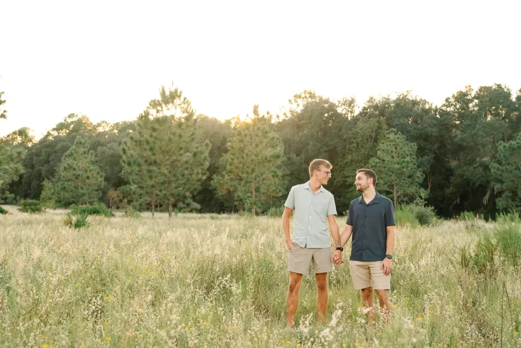 Couple holding hands standing in field in Florida