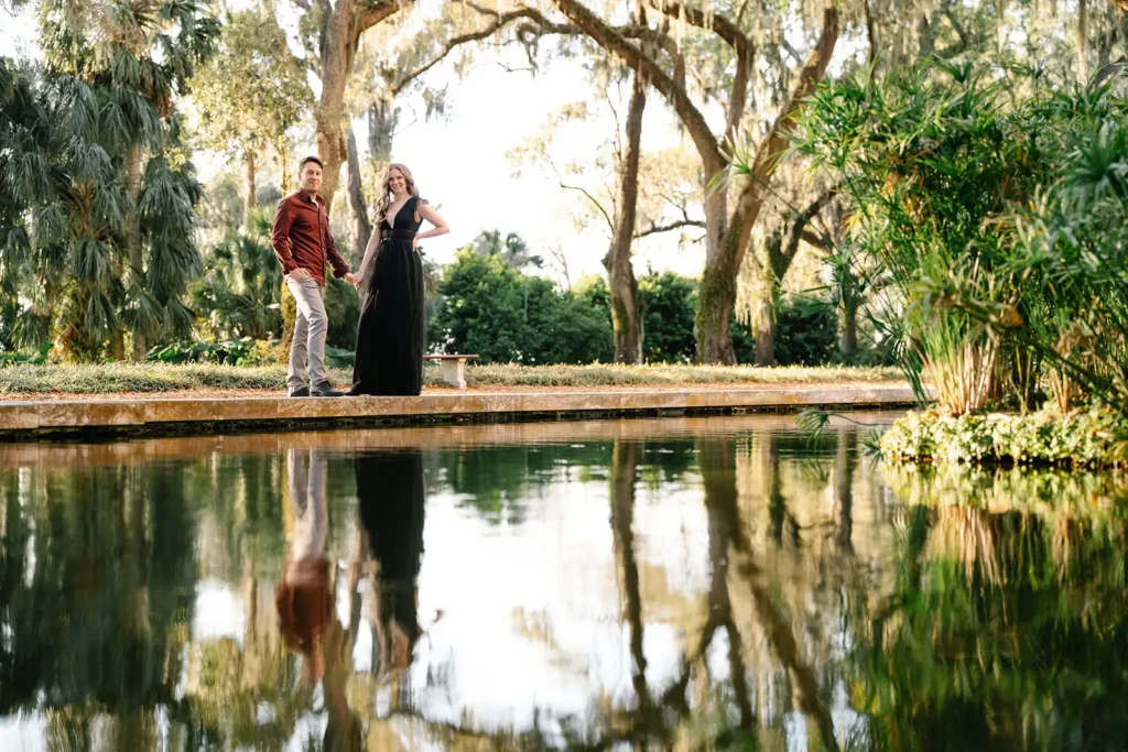 Couple stasnding by pond surrounded by trees