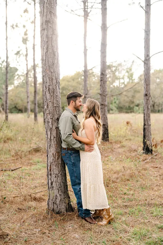 Man leaning on tree embracing woman