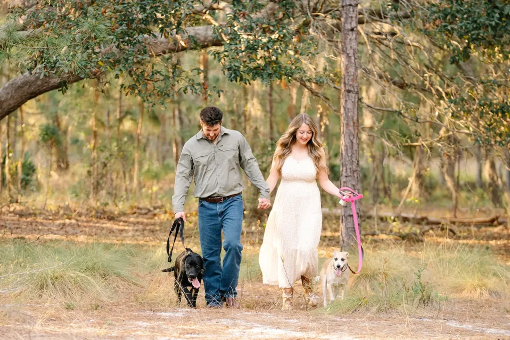 Couple walking in woods with two dogs