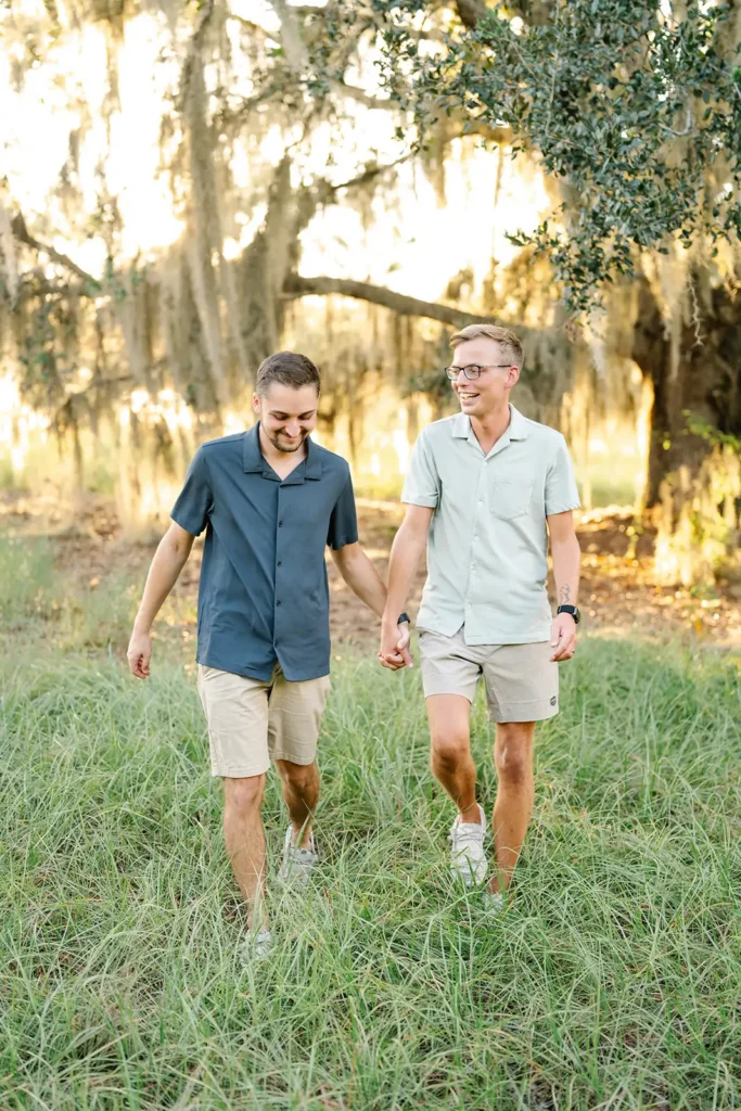 Couple walking through a field by a lake