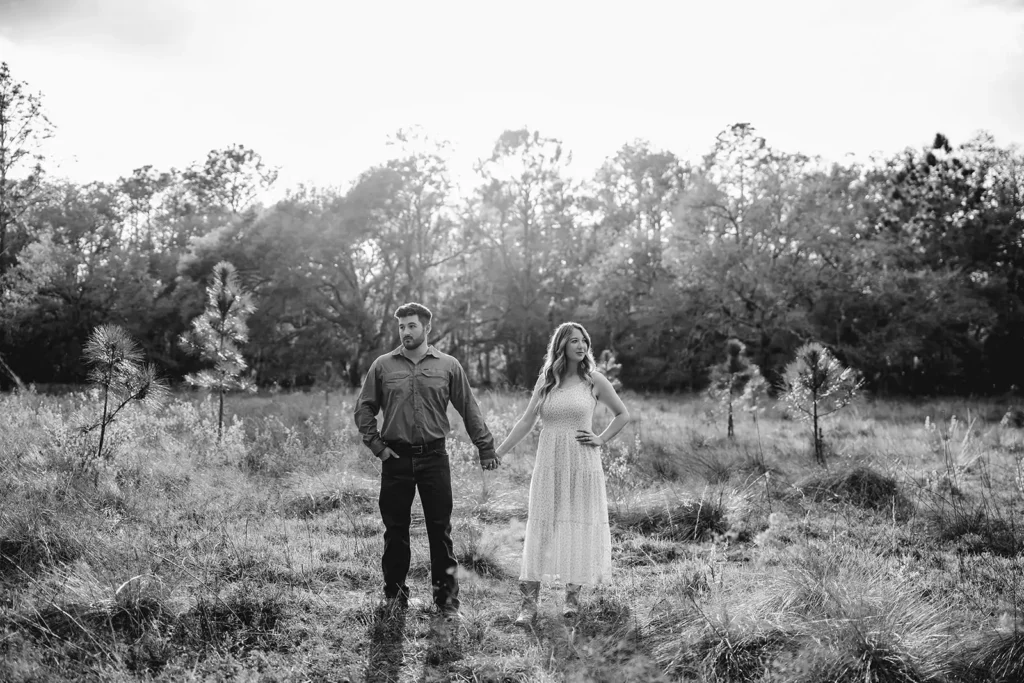 Black and white photo of engaged couple in a field