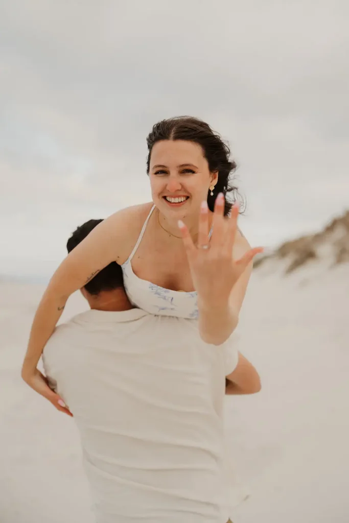 woman over man's shoulder showing engagement ring
