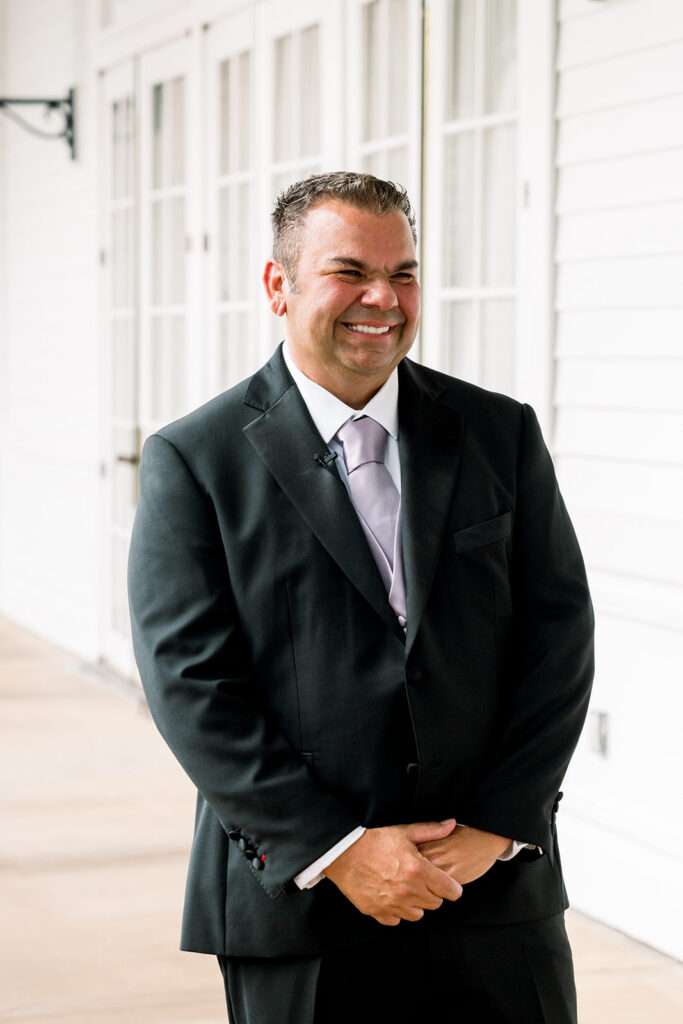 father grins at bride during first look