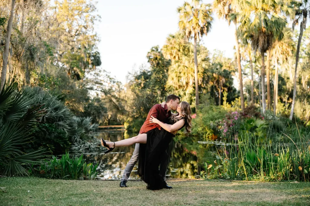 Engaged couple kssing outside by pond in Central Florida