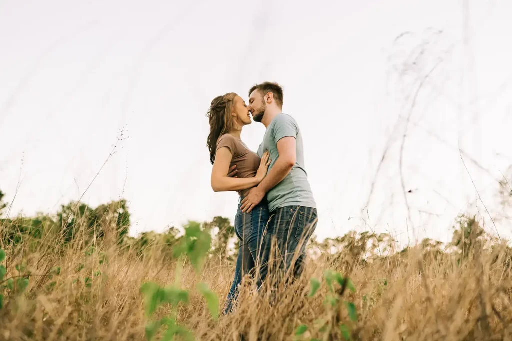 Couple kisses in field in Clermont, FL for engagement photo