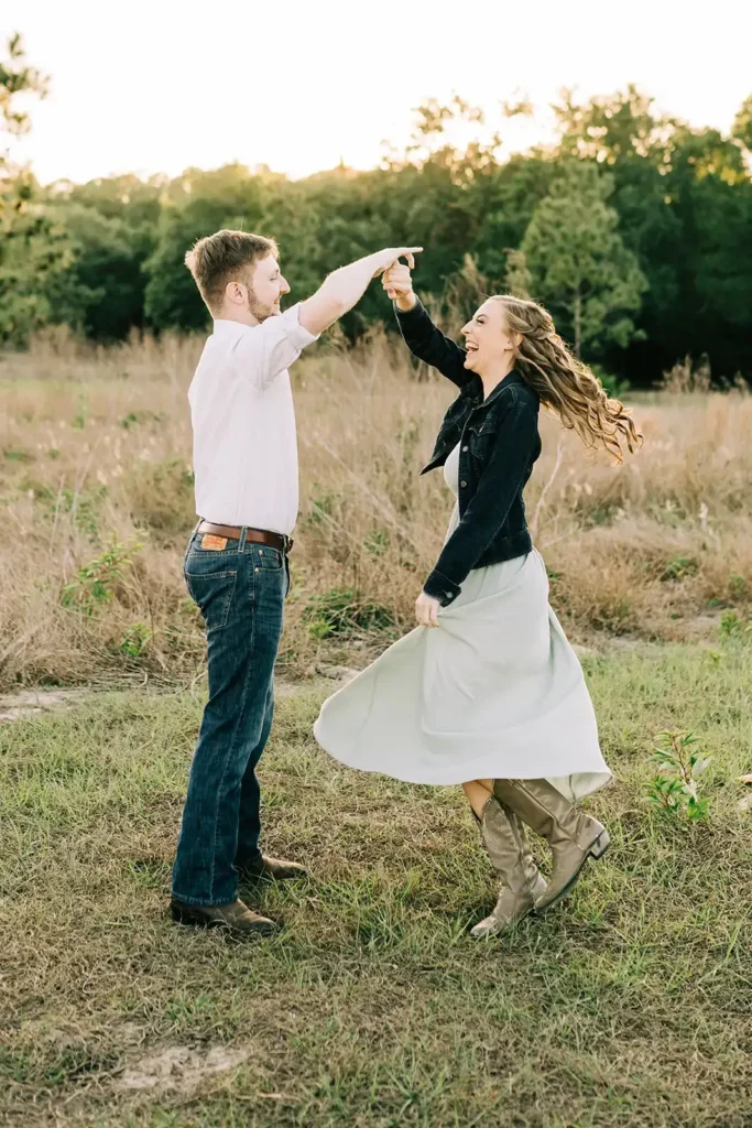 Man spins woman in large field