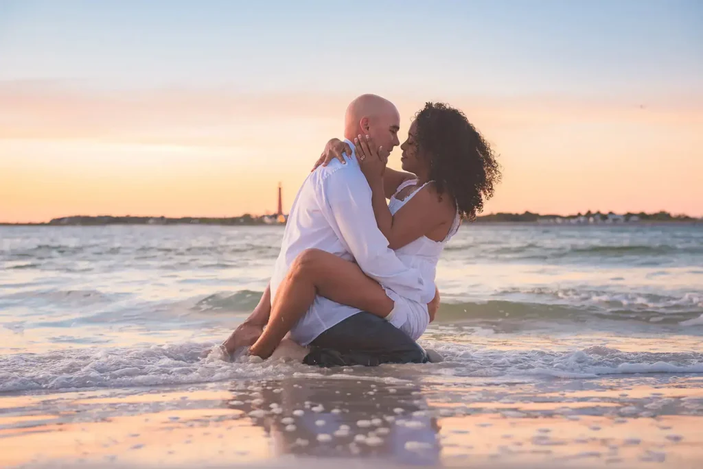 Couple sitting in the surf for engagement photo